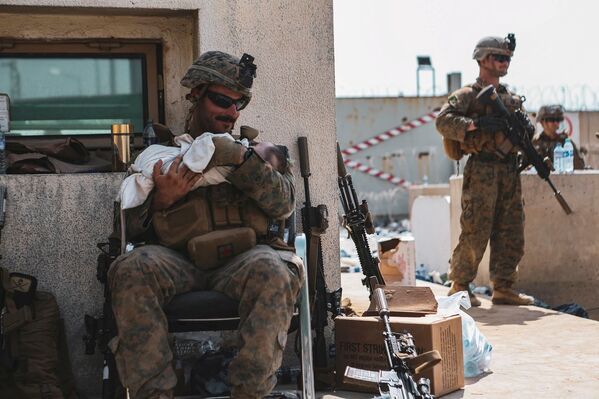 Американский солдат с младенцем в аэропорту Кабула  - Sputnik Южная Осетия