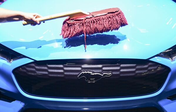 Рабочий чистит капот электромобиля Ford Mustang Mach-E GT на стенде Ford на открытии Международного Мюнхенского автосалона в Германии - Sputnik Южная Осетия
