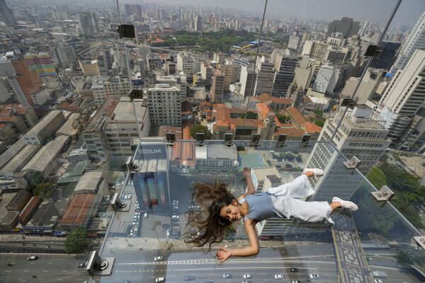 Девушка лежит на стеклянной смотровой площадке Sampa Sky здания Mirante do Vale в Сан-Паулу, Бразилия - Sputnik Южная Осетия
