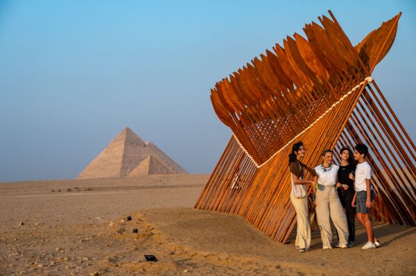 Люди у инсталляции египетского художника Moataz Nasr на выставке Forever Is Now у пирамид Гизы в Египте - Sputnik Южная Осетия