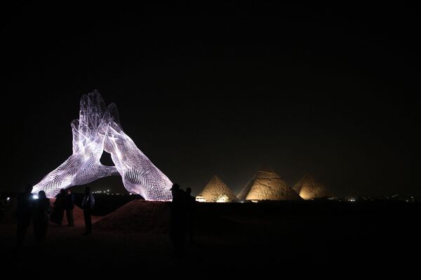 Инсталляция итальянского художника Lorenzo Quinn ночью на выставке Forever Is Now у пирамид Гизы в Египте - Sputnik Южная Осетия