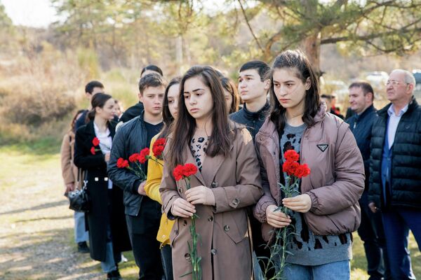 Люди несли к камню, где планируется построить памятник подвигу, розы и красные гвоздики. - Sputnik Южная Осетия