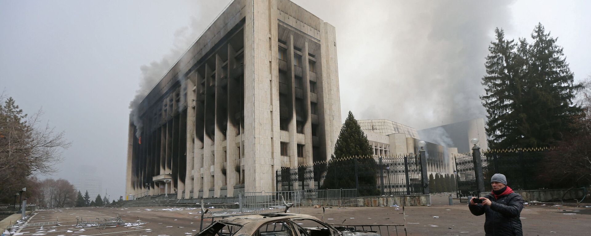 Сгоревший автомобиль перед зданием мэрии, которое было подожжено во время протестов в Алматы - Sputnik Южная Осетия, 1920, 07.01.2022