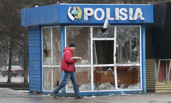 Мужчина проходит мимо полицейского участка, разрушенного в ходе беспорядков в Алматы. - Sputnik Южная Осетия