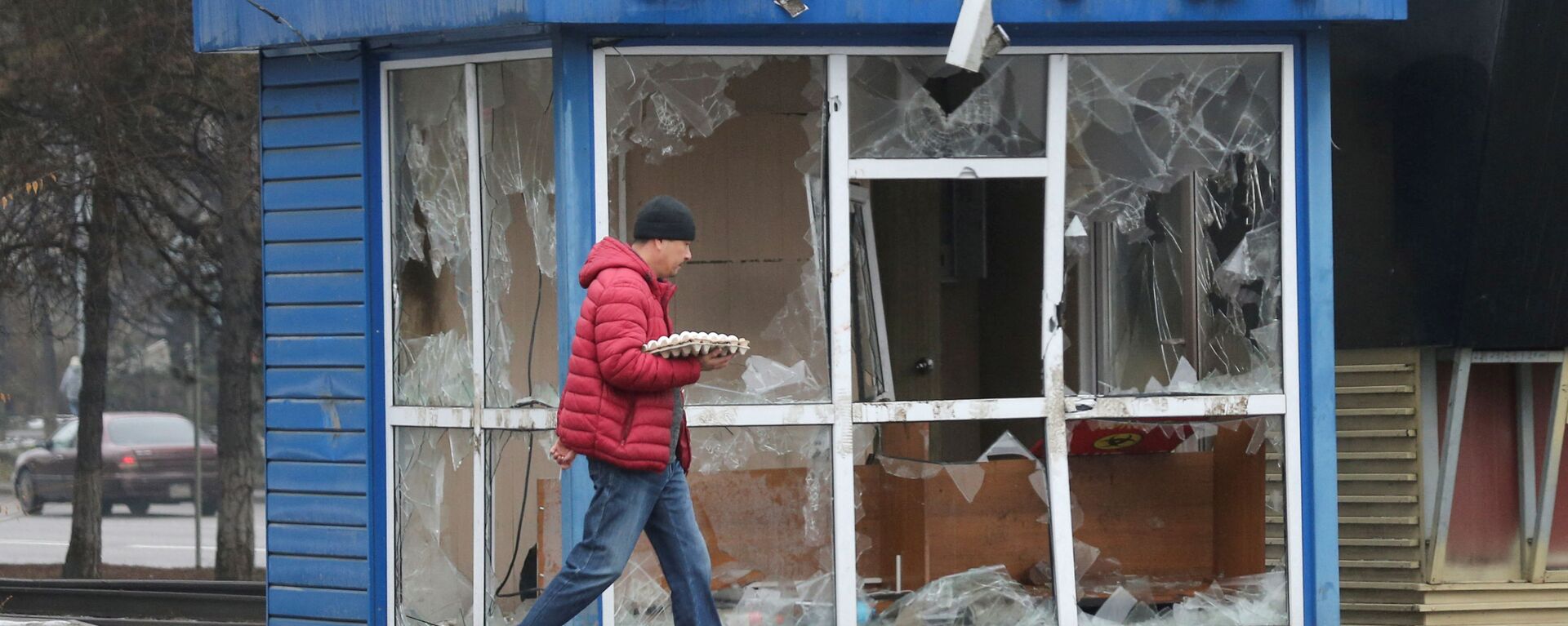 Мужчина проходит мимо полицейского участка, разрушенного во время беспорядков в Алматы - Sputnik Южная Осетия, 1920, 10.01.2022