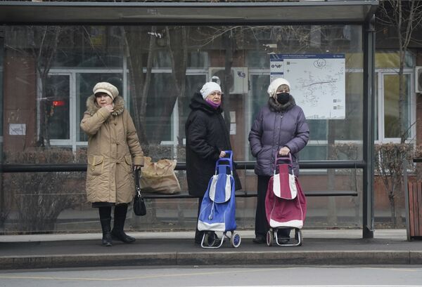 Женщины ждут автобус на автобусной остановке в Алматы, Казахстан, 10 января 2022 года - Sputnik Южная Осетия