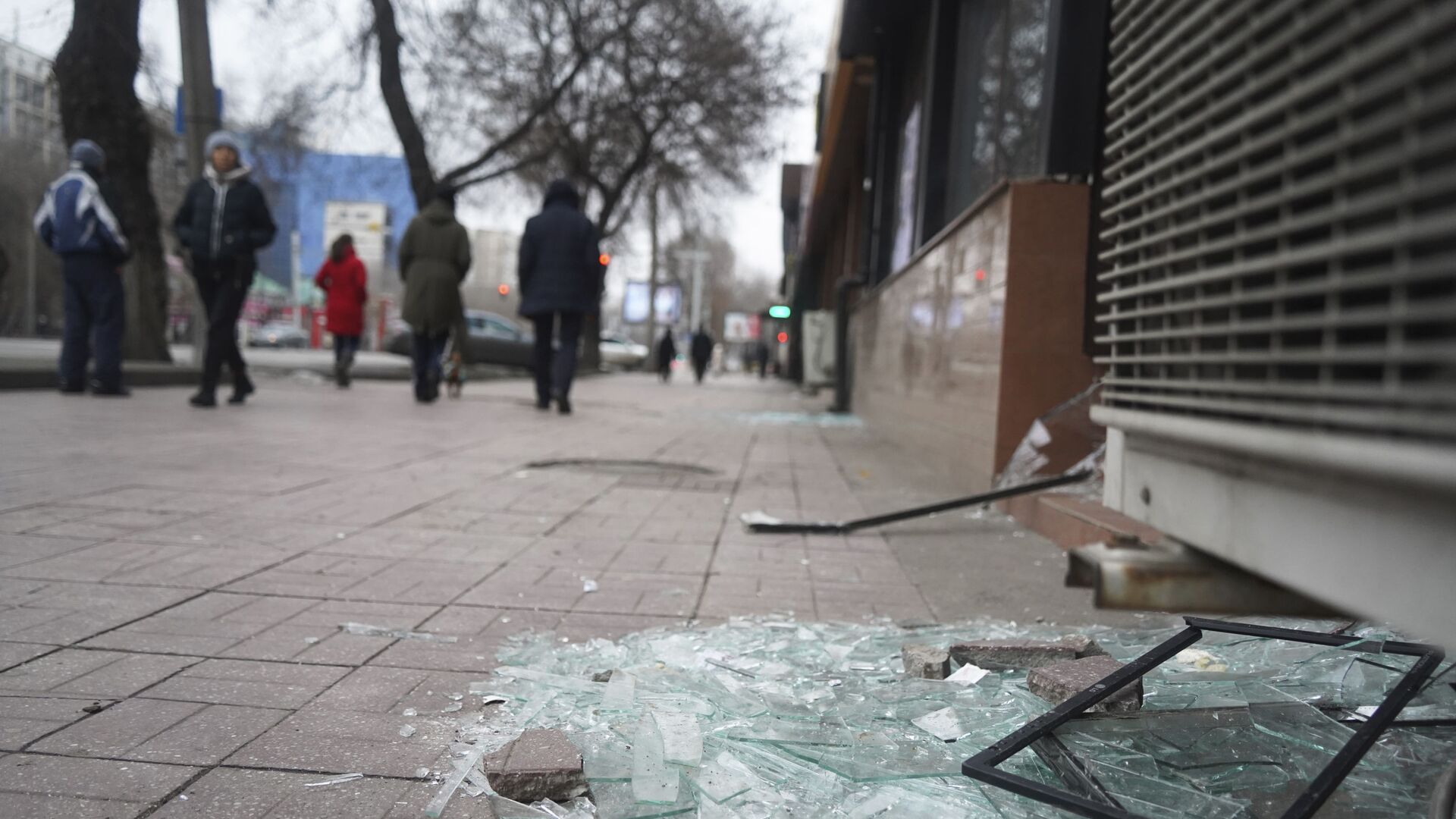 Люди проходят мимо магазина с разбитыми окнами в Алматы - Sputnik Южная Осетия, 1920, 10.01.2022