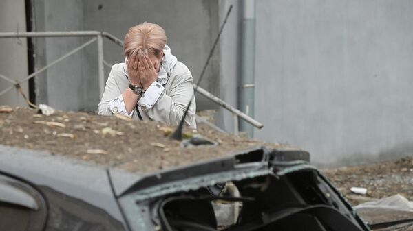 Жительница во дворе жилого дома, подвергшегося обстрелу, в Киевском районе Донецка - Sputnik Южная Осетия