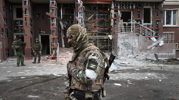 Военнослужащие во дворе поврежденного многоэтажного дома в Донецке - Sputnik Южная Осетия