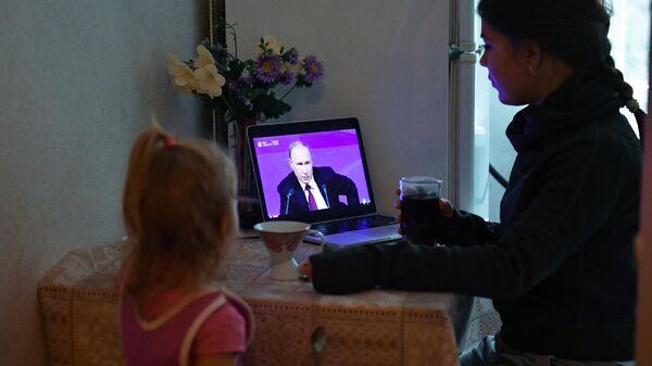 Женщина с ребенком смотрят обращение президента РФ Владимира Путина. Архивное фото  - Sputnik Южная Осетия