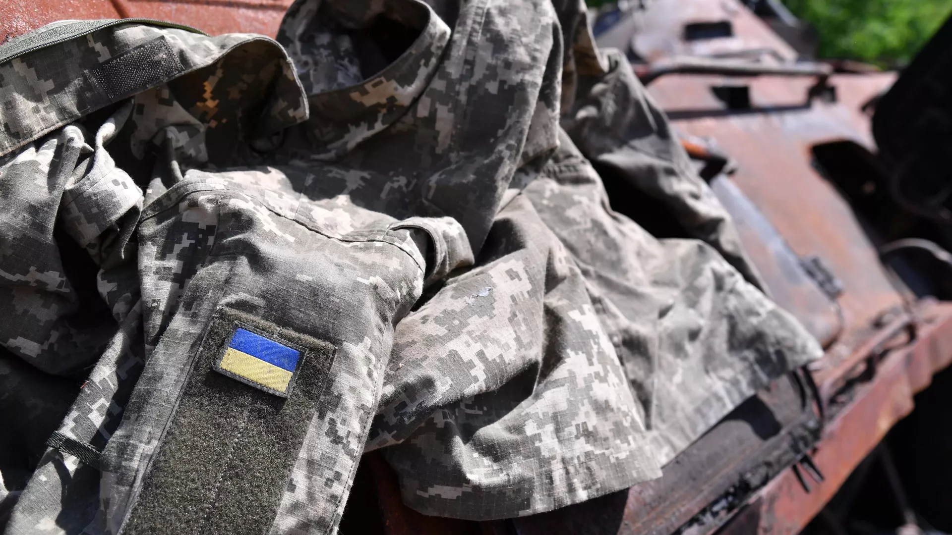 Обмундирование украинского военнослужащего и подбитый БТР ВСУ в ДНР