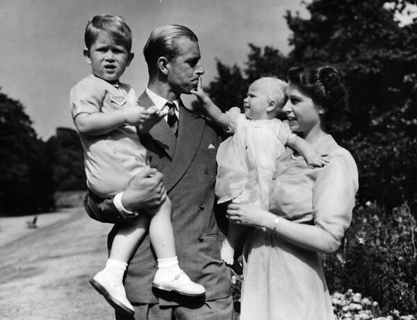 Британская королева Елизавета II, в то время принцесса Елизавета, стоит со своим мужем принцем Филиппом, герцогом Эдинбургским, и их детьми  - Sputnik Южная Осетия
