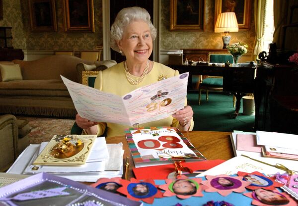 Королева Великобритании Елизавета II сидит в Зале Регентства в Букингемском дворце в Лондоне 19 апреля 2006 года, рассматривая открытки, присланные ей на ее 80-летие. - Sputnik Южная Осетия