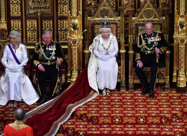 Королева Великобритании Елизавета II на троне в Палате лордов рядом со своим мужем, принцем Филиппом, герцогом Эдинбургским (справа), сыном, принцем Чарльзом, принцем Уэльским (вторая слева) и его женой Камиллой, герцогиней Корнуольской, готовится произнести речь королевы во время государственного открытия парламента в Вестминстерском дворце в Лондоне, среда, 27 мая 2015 г. - Sputnik Южная Осетия