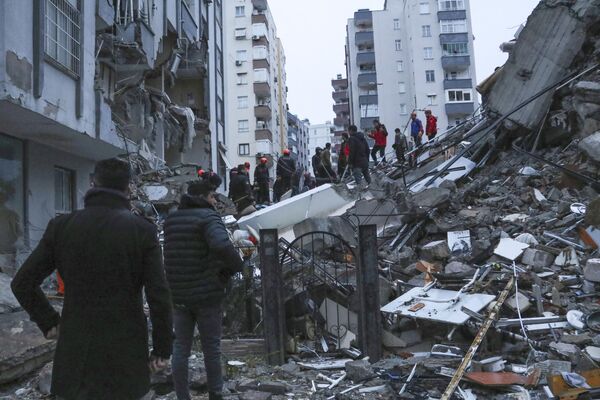 Спасательные команды пытаются добраться до жителей, оказавшихся в ловушке внутри разрушенных зданий в Адане, Турция. - Sputnik Южная Осетия