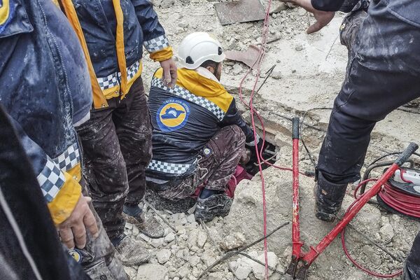 Члены гражданской обороны Сирии ищут людей под обломками разрушенного здания в Африне, Сирия. - Sputnik Южная Осетия