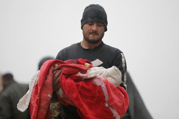 Сириец несет тело младенца, погибшего в результате землетрясения в городе Джандарис в сельской местности города Африн в сирийской провинции Алеппо. - Sputnik Южная Осетия