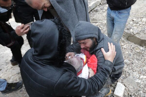 Сириец плачет, неся тело своего сына, погибшего в результате землетрясения в городе Джандарис в сельской местности города Африн на северо-западе Сирии. - Sputnik Южная Осетия