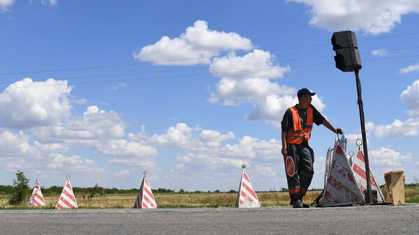  Рабочий следит за движением автотранспорта во время ремонта участка автомобильной дороги . Архивной фото - Sputnik Южная Осетия