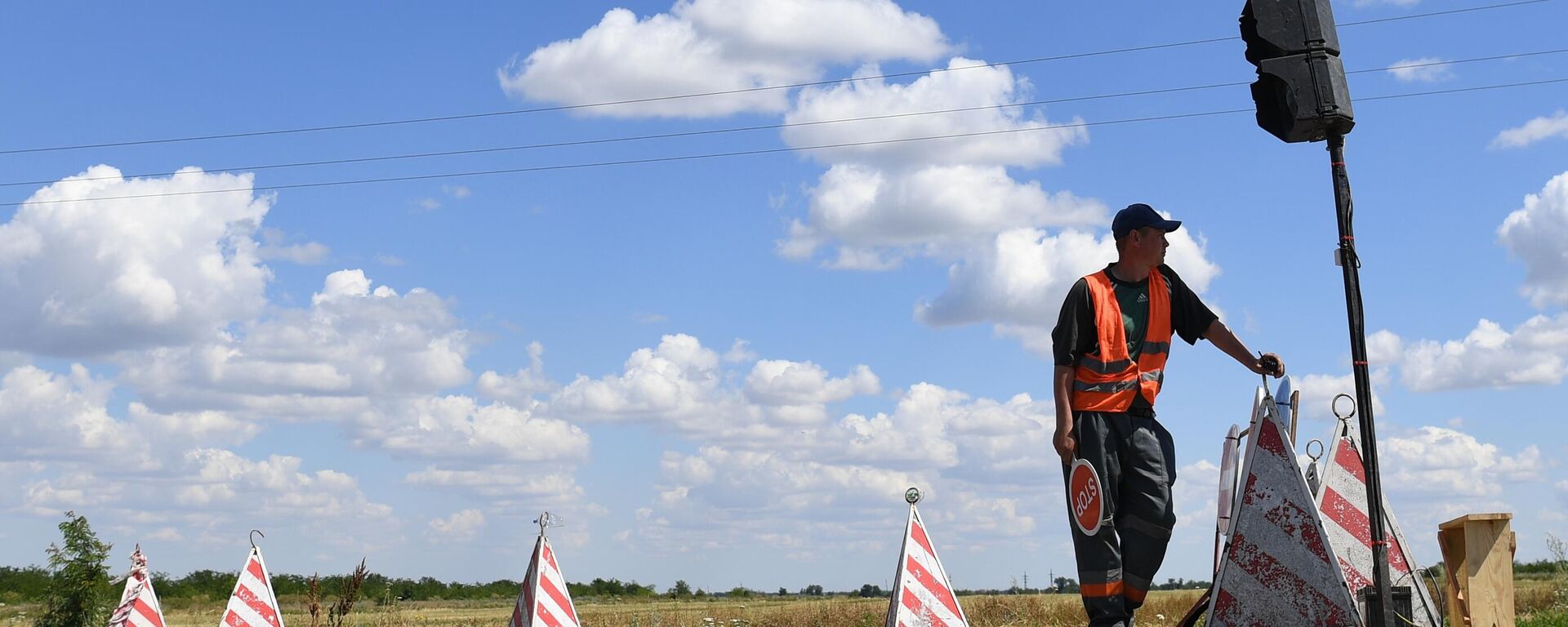  Рабочий следит за движением автотранспорта во время ремонта участка автомобильной дороги . Архивной фото - Sputnik Южная Осетия, 1920, 09.10.2024