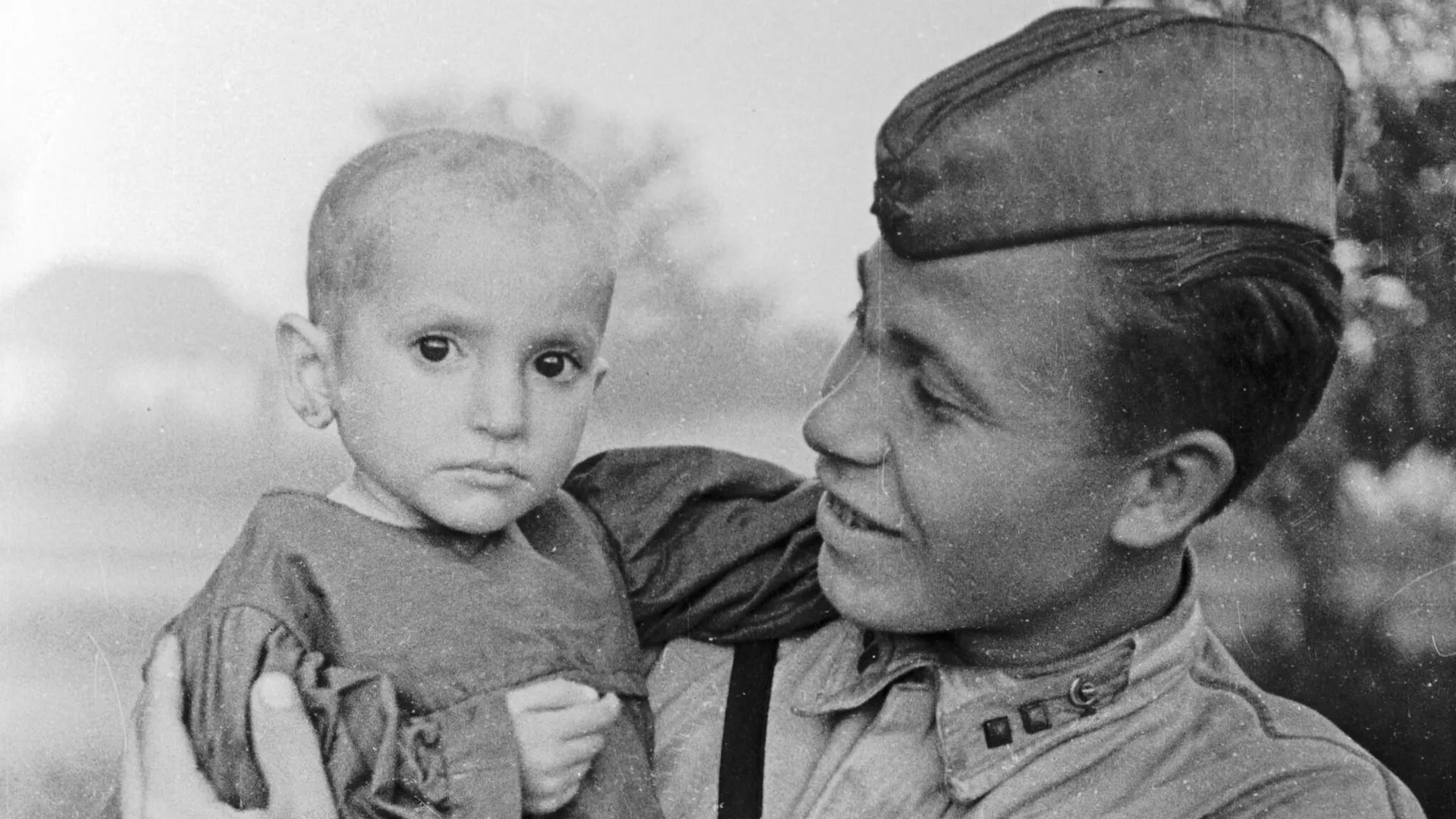 На руках у советского офицера спасенная девочка из деревни Эльхотово.