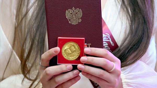 Учащаяся 11 класса держит свой аттестат и золотую медаль. Архивное фото - Sputnik Южная Осетия