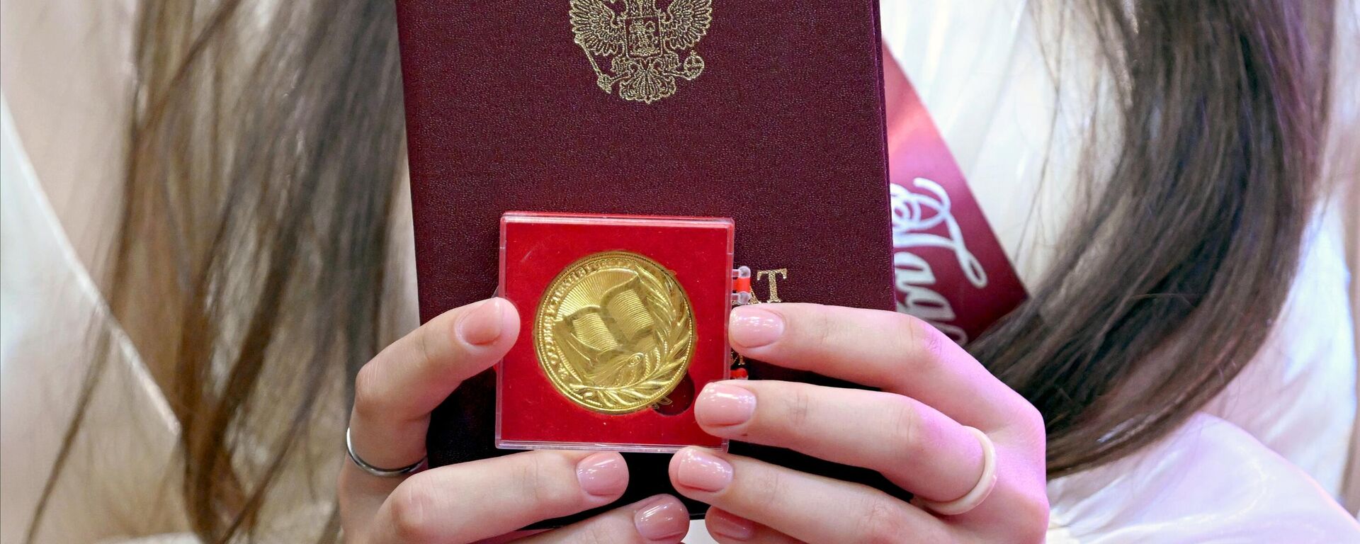 Учащаяся 11 класса держит свой аттестат и золотую медаль. Архивное фото - Sputnik Южная Осетия, 1920, 30.04.2024