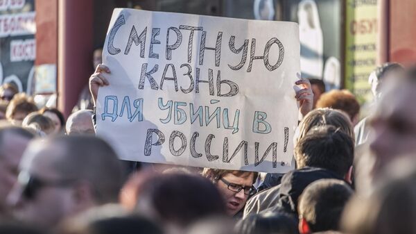 Житель Белгорода держит плакат с требованием смертной казни для виновных в убийствах. Архивное фото - Sputnik Южная Осетия