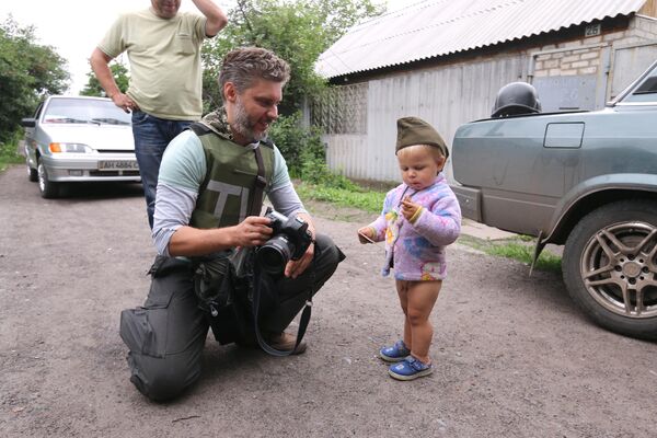 Специальный фотокорреспондент МИА Россия сегодня Андрей Стенин и мальчик Антон Кобченко в селе Семеновка - Sputnik Южная Осетия