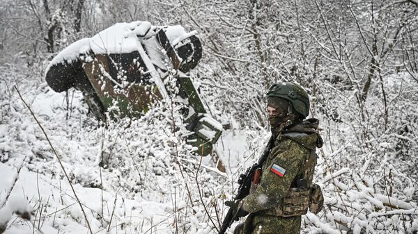 Российский военнослужащий  возле подбитого бронеавтомобиля ВСУ в Курской области - Sputnik Южная Осетия