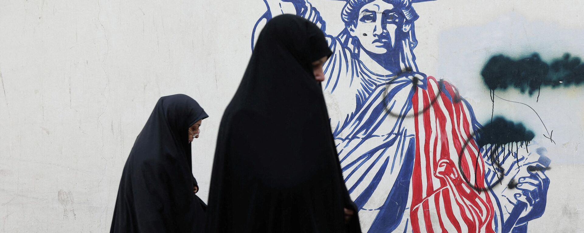 Женщины проходят мимо антиамериканского мурала на улице в Тегеране. Архивное фото  - Sputnik Южная Осетия, 1920, 09.02.2026