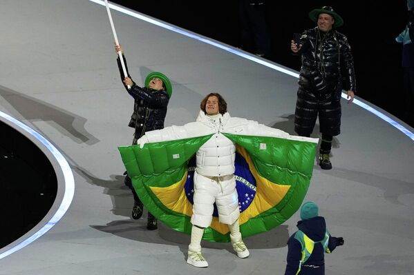 Бразильский горнолыжник Лукас Пинейро Браатен на церемонии открытия парада олимпийской команды в длинной белой пуховой куртке от Moncler, украшенной изнутри бразильским флагом. - Sputnik Южная Осетия