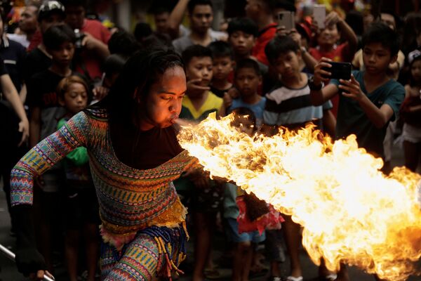 Уличная артистка выдувает огонь изо рта на праздновании Китайского нового года в Маниле, Филиппины - Sputnik Южная Осетия