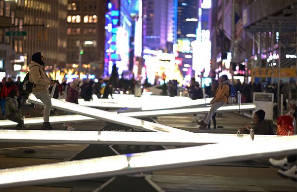 Люди катаются на светящихся качелях на Бродвее недалеко от Тайм-сквер в Нью-Йорке - Sputnik Южная Осетия