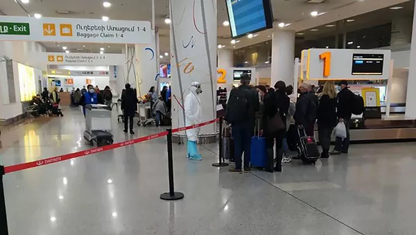 Сотрудник Минздрава в спецодежде встречает пассажиров из Ирана
