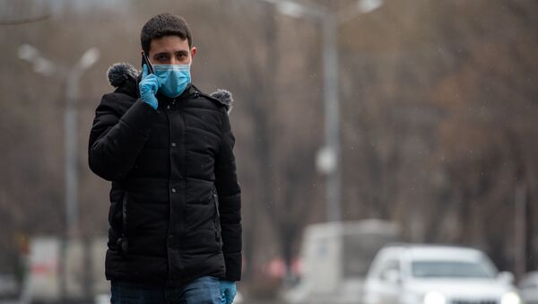 Молодой человек в защитной маске и перчатках на улице - Sputnik Южная Осетия