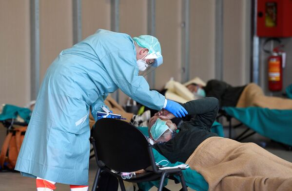 Врач помогает пациенту во временной больнице в Брешиа, Италия - Sputnik Южная Осетия