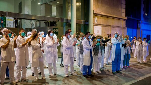 Медработники аплодируют людям, которые поддерживают их с балконов своих квартир, у здания больницы в Барселоне - Sputnik Южная Осетия