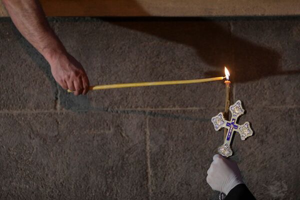 Священнослужитель с крестом и свечой во время празднования Пасхи в Румынии  - Sputnik Южная Осетия