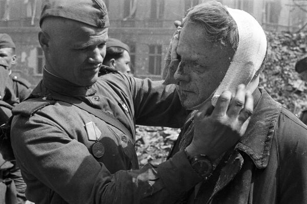Советский солдат делает перевязку раненому берлинцу, 1945 год - Sputnik Южная Осетия