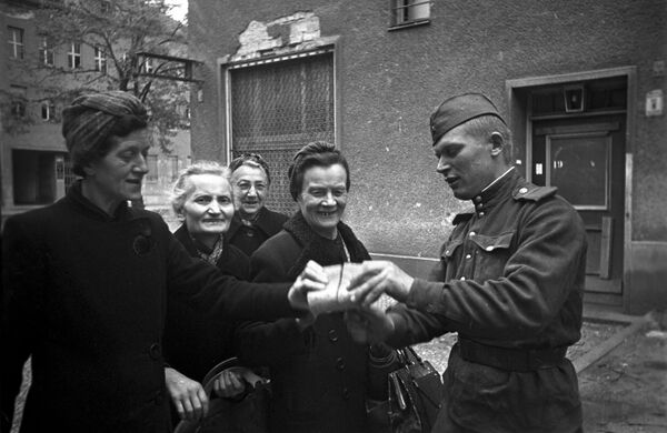 Советский солдат раздает хлеб женщинам Берлина, 7 мая 1945 года - Sputnik Южная Осетия