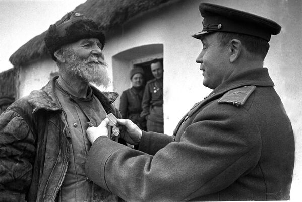 Командир дивизиона награждает колхозника Помкина за подвиг. 3-ий Украинский фронт. 1945 год - Sputnik Южная Осетия