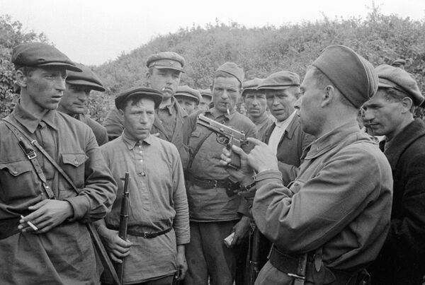 Командир партизанского отряда знакомит бойцов с оружием. Смоленская область, 1941 год - Sputnik Южная Осетия
