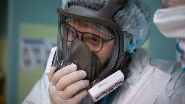 Медик в защитной маске в стационаре для больных с коронавирусом. Архивное фото - Sputnik Южная Осетия