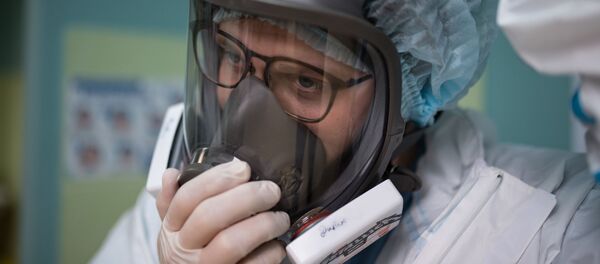 Медик в защитной маске в стационаре для больных с коронавирусом. Архивное фото - Sputnik Южная Осетия