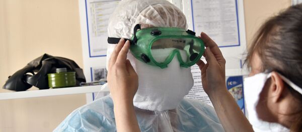 Врач одевает защитный комбинезон, очки, маску, перчатки Врач одевает защитный комбинезон, очки, маску, перчатки - Sputnik Южная Осетия