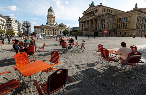 Люди наслаждаются погодой в кафе на площади Жандарменмаркт в Берлине, соблюдая принцип социальной дистанции - Sputnik Южная Осетия