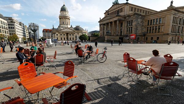 Люди наслаждаются погодой в кафе на площади Жандарменмаркт в Берлине, соблюдая принцип социальной дистанции - Sputnik Южная Осетия