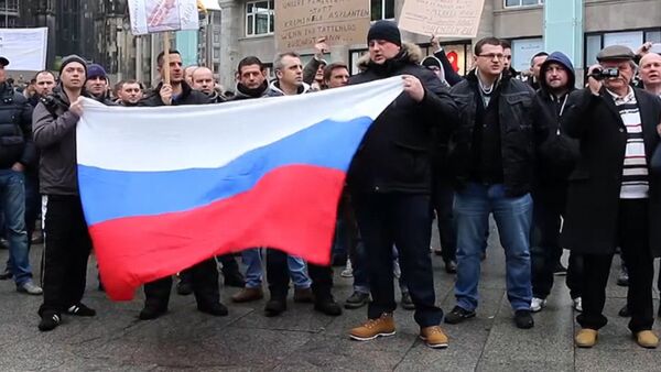 Кельнцы с флагами РФ вышли на митинг из-за инцидента с девочкой в Берлине - Sputnik Южная Осетия