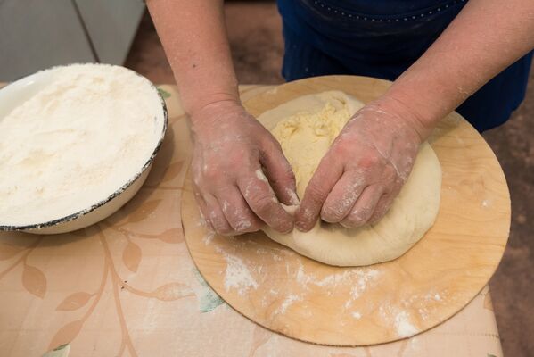 Готовое тесто раскатывается и разминается в лепешку, подготовленная начинка выкладывается на середину лепешки, после чего тесто защипывается. - Sputnik Южная Осетия